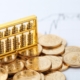 golden-abacus-with-chinese-rmb-gold-coins-as-background-min